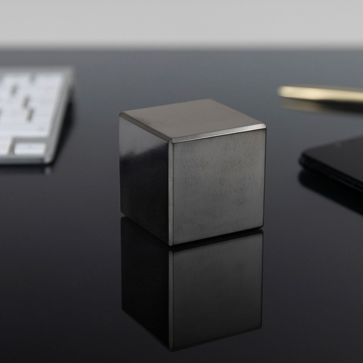 A precision-machined niobium cube photographed to show its natural metallic colour and finish.