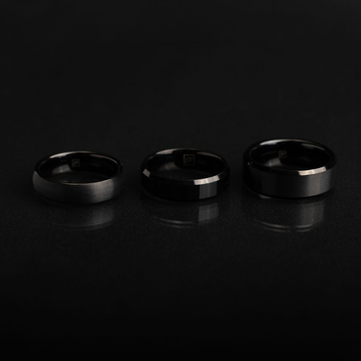 A black tungsten ring photographed close-up to show its dark finish, substantial width and clean profile.