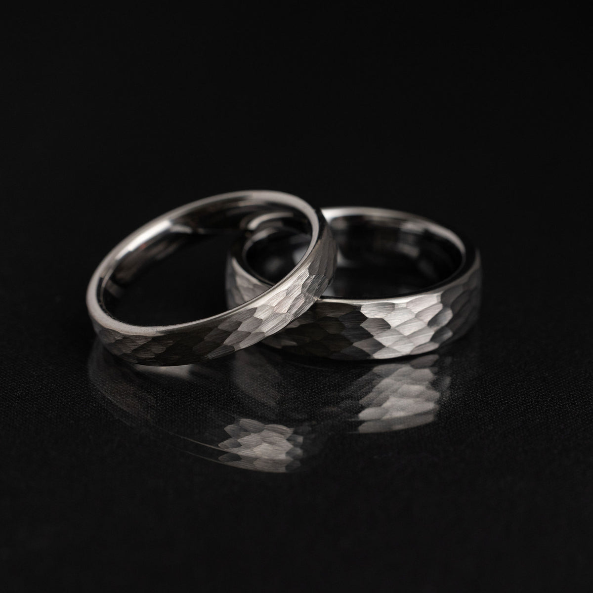 A hammered tungsten ring photographed in directional light to show the small facets across its textured surface.